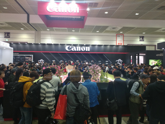 19일 서울 삼성동 코엑스에서 열린 서울국제사진영상전의 캐논코리아컨슈머이미징 부스에서 관람객들이 사진을 찍고 있다.